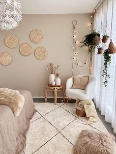 a bedroom decorated in neutrals and whites with fur rugs on the floor, lights hanging from the ceiling