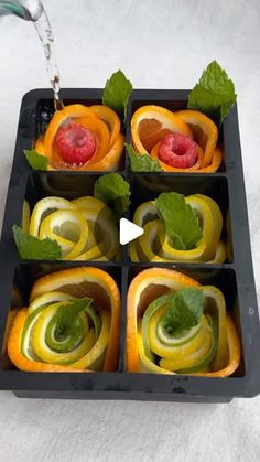 an assortment of fruits and vegetables in a tray with water running from the top to the bottom