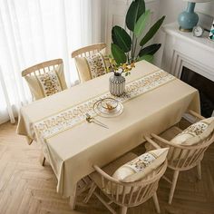 a dining room table with chairs and a vase filled with flowers