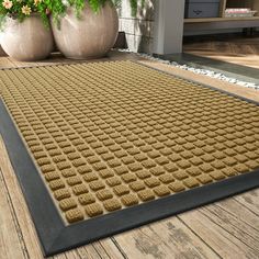 a large mat on the ground in front of some potted plants and two planters