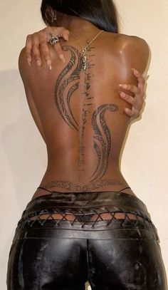 the back of a woman with tattoos on her body