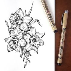 a drawing of flowers on paper next to markers