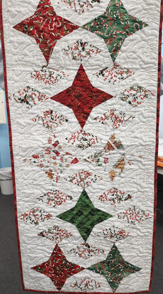 a white quilt with red and green stars on it