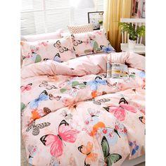 a bed with pink sheets and butterflies on it