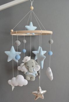 a baby mobile with stars and an elephant in the middle hanging from it's side