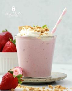 a strawberry milkshake with whipped cream and fresh strawberries on the side for garnish