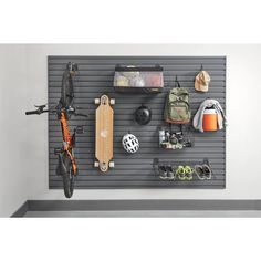 there is a wall mounted bike rack with many items hanging on the wall behind it