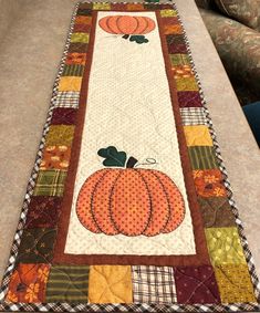 a quilted table runner with pumpkins on it