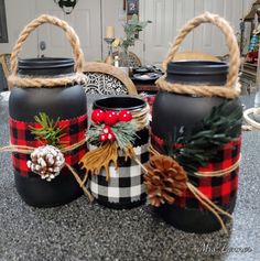 two black jars decorated with pine cones and plaid bows