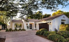 a white house with trees and bushes around it