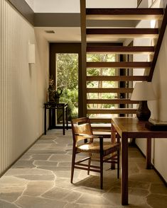 a wooden table sitting under a stair case