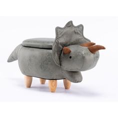 a toy rhinoceros sitting on top of a small stool with its trunk sticking out