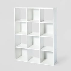 a white bookcase with twelve cubes on each side and one section missing from the top