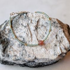 The perfect combination of coral Sunstone and light sea foam green. The Sunstone gemstone in this bracelet is absolutely stunning. It has a deep coral color with flashes of gold. They pair beautifully with the sea foam green glass beads. Sunstone is associated with the Sun's radiant energy. This is a stone that enhances your personal power and instills your life with joy, courage and optimism. This is a stone that you want close to you at all times. Colors: This beaded bracelet features matte gl Coral Beach Bracelet Jewelry, Adjustable Coral Stretch Bracelet, Sunstone Bracelet Gemstones, Sunstone And Moonstone Bracelet, Adjustable Hand-strung Coral Bracelets, Coral Bracelet, Seafoam Green, Coral Color, Sea Foam