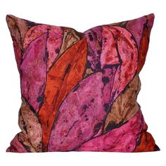 a pink and orange pillow with leaves on it's side, against a white background