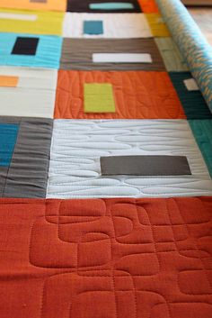 an orange and blue quilt with squares on it