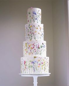 a multi - tiered cake with flowers painted on it