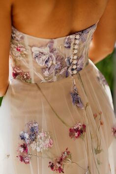 the back of a woman's dress with flowers on it