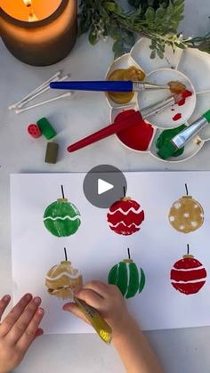 someone is making christmas ornaments out of construction paper with glue and paint on the table