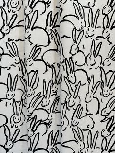 a black and white drawing of many rabbits on a sheet that has been drawn onto it