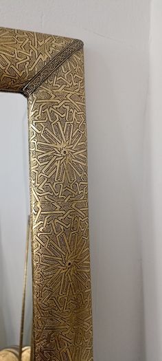 a gold colored mirror sitting on top of a table