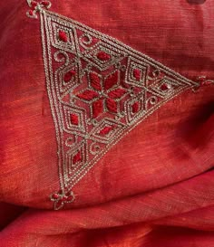 an embroidered red cloth with silver threadwork