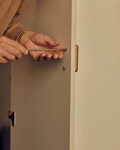 a person is opening a door with a pair of scissors in their hand and holding the handle