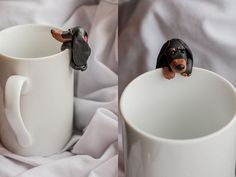 two coffee mugs with miniature dachshund figurines sitting on them