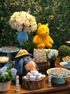 a winnie the pooh birthday party with desserts and snacks on a table next to a teddy bear