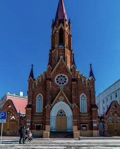 an old church with two people walking by it