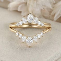 a gold ring with three pear shaped diamonds on top and two smaller pears in the middle