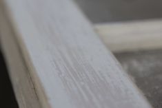 a close up view of the edge of a window sill, with only one piece of wood visible