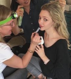 two women are having their hair brushed by another woman