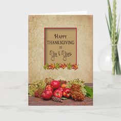 a happy thanksgiving card with pomegranates and pine cones on the table