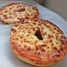 two cheese bagels sitting on top of white paper