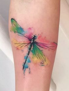 an image of a colorful dragonfly tattoo on the side of a woman's leg