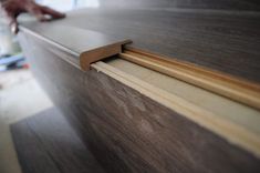 a close up of a person's hand on the edge of a wooden table