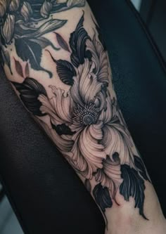 a black and white flower tattoo on the arm