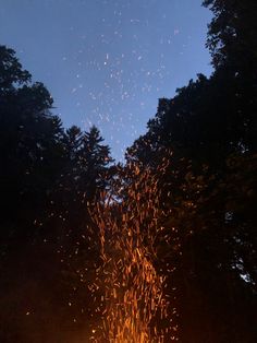 the fire is glowing brightly in the night sky with lots of sparks coming from it