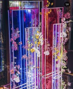 a display case with flowers and butterflies on it's sides in front of a window