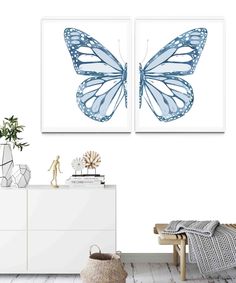 two blue butterflies are hanging on the wall next to a white dresser and sideboard