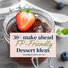 a jar filled with chocolate pudding next to blueberries and strawberries on the side