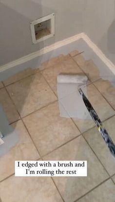 a bathroom floor that has been cleaned with a brush and paper towel on the ground