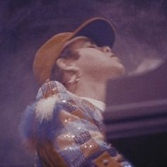 a man with his eyes closed wearing a baseball cap and looking up into the sky