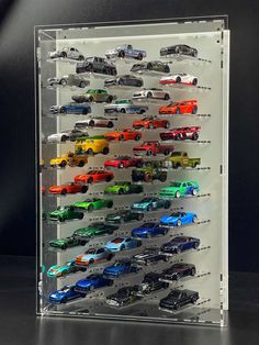 a display case filled with lots of different colored toy cars on top of each other