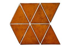 a brown and white tiled wall with four triangles on the top one is made out of cement