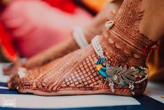 the feet and ankles of a woman with henna tattoos on their feet, decorated with jewels