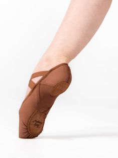 a woman's feet wearing brown ballet shoes