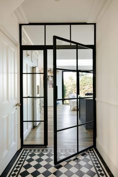 an open door leading into a room with black and white checkered flooring on the walls