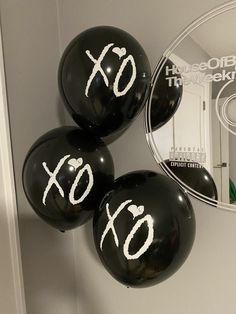 three black balloons with xo written on them in front of a cd and mirror